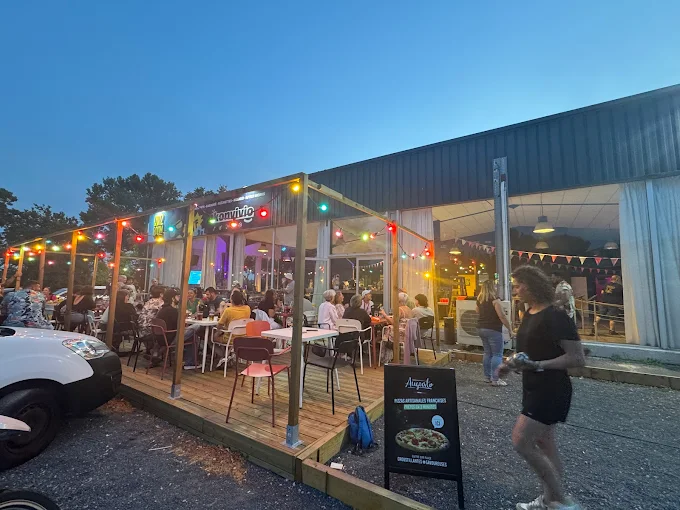 Photo de l'espace bar d'ambiance extérieur de Konvivio, avec des personnes entrain de déguster des tapas et des boissons